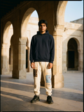 Heritage Trouser in bone worn with the Heritage Hoodie in a limestone courtyard