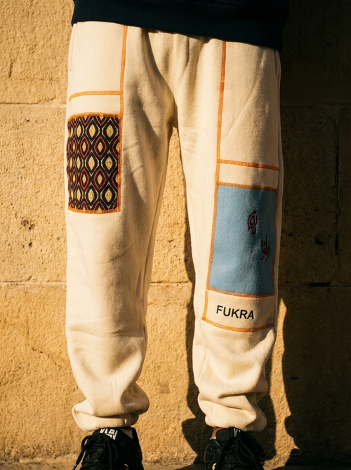 Heritage Trouser detail — ajrak patch, sky-blue panel and saffron seams in golden-hour light
